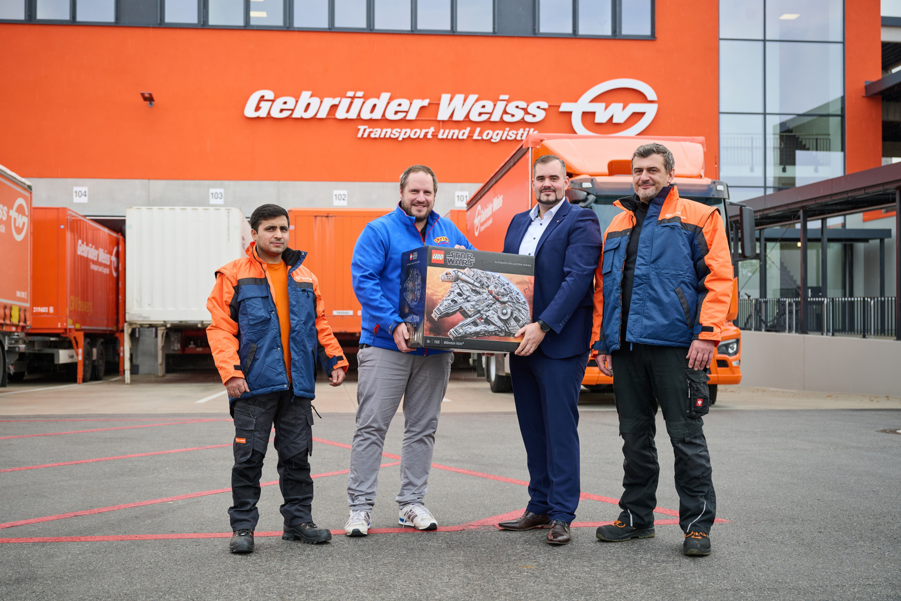 Harbingers of Santa Claus in Straubing (from left to right): Qaseem Hotak (warehouse clerk at Gebrüder Weiss), Robin Kühn (Wallersdorf site manager at Smyths Toys), Thomas Peklo (Straubing branch manager at Gebrüder Weiss) and Christian Kurz (shift manager logistics at Gebrüder Weiss) (Source: Gebrüder Weiss / Popp)